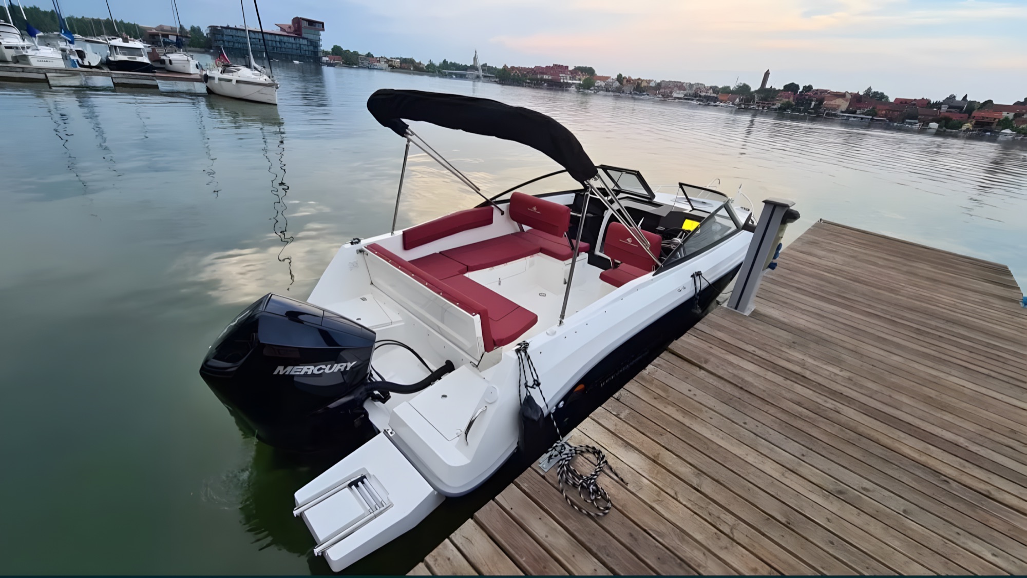 Łódź Atlantic Marine 720 Day Cruiser przy pomoście, w tle zabudowa Mikołajek