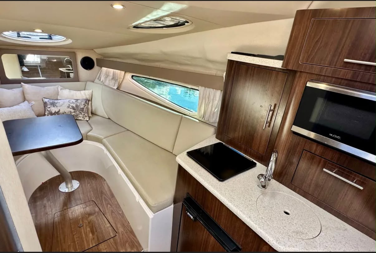Regal 28 Express — kabina z kanapą, stołem i aneksem kuchennym